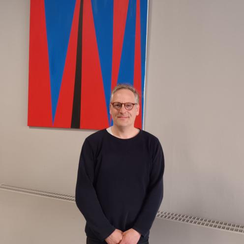Foto af kunstner Søren Kragh foran hans kunstværk