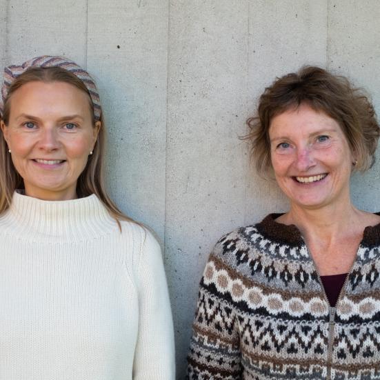Foto af Marianne og Thea op ad en lys væg
