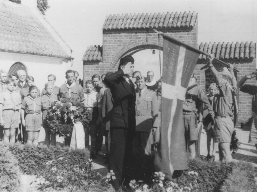 Sort-hvid foto: FDF’ere og drenge fra britiske Boys Brigade ved de to flyveres grave på Tveje Merløse Kirkegård.