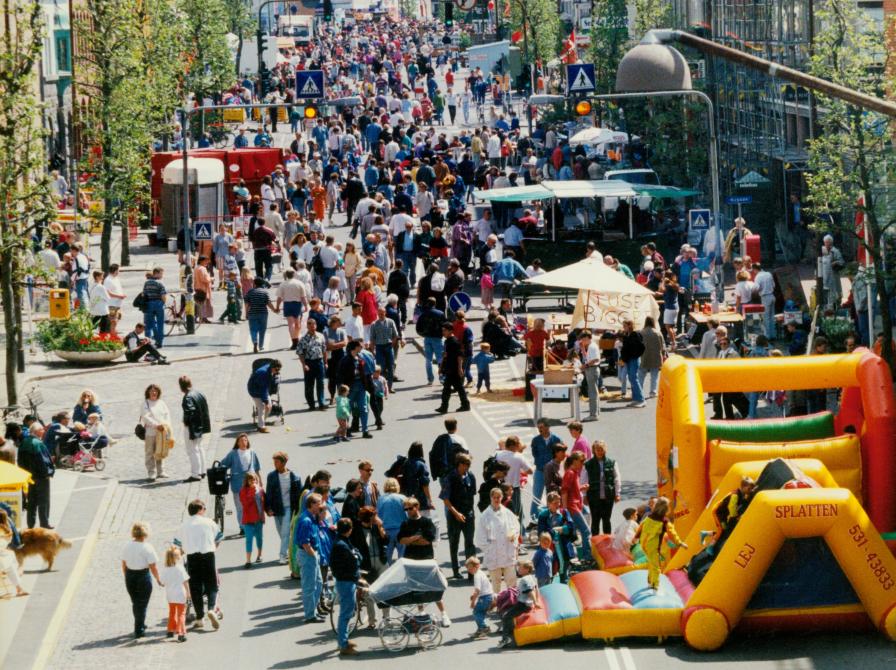 Farvefoto af Ahlgade i 1995 med hoppeborg og mange deltagere til Børnehjælpsdagen.