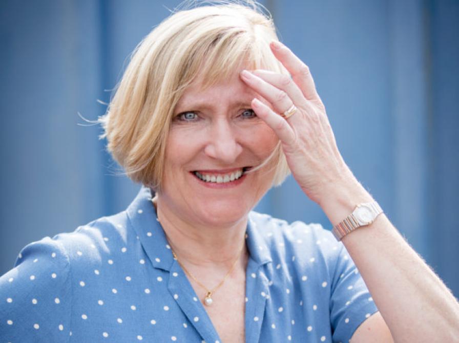 Foto af Pernille Juhl i blå skjorte på blå industriel baggrund.